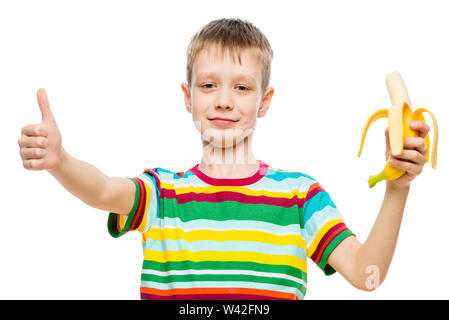 Portrait Of Happy Boy auf weißem Hintergrund mit einer Banane in der Hand isoliert Stockfoto