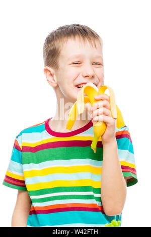 Vertikale Porträt eines Jungen, der eine leckere Banane auf weißem Hintergrund isst, Porträt ist isoliert Stockfoto