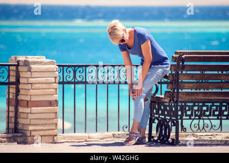 Junge Frau mit Knieschmerzen während Outdoor wandern. Gesundheit, Medizin, Personen Konzept Stockfoto