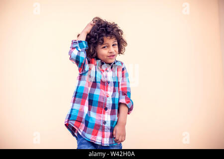 Kleiner Junge mit lockigem Haar Denken über etwas. Kinder und Emotionen Konzept Stockfoto