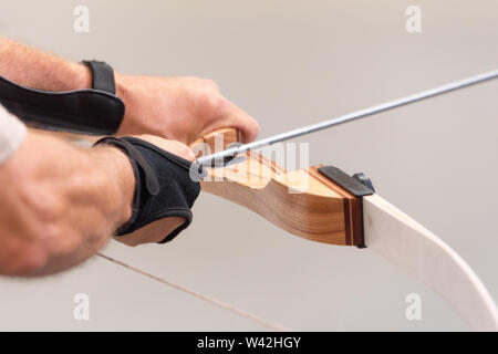 Archer Hände close up, die Vorbereitung der Pfeil für den Schuss. Stockfoto