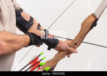 Archer Hände close up, die Vorbereitung der Pfeil für den Schuss. Stockfoto