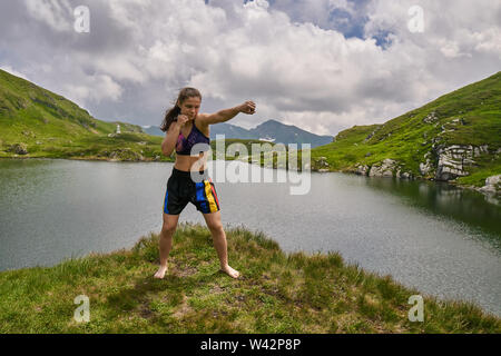 Kickboxer Mädchen Training an einem See in den Bergen Stockfoto