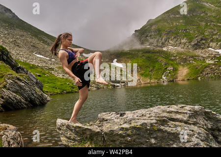 Kickboxer Mädchen Training an einem See in den Bergen Stockfoto