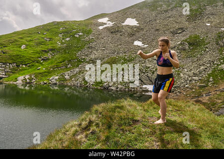 Kickboxer Mädchen Training an einem See in den Bergen Stockfoto