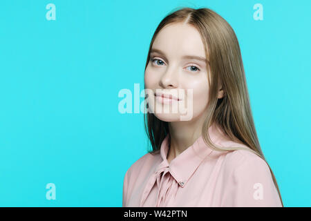 Portrait einer jungen lächelnde Mädchen auf blauem Hintergrund-Bild Stockfoto