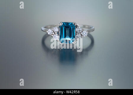 Ein Emerald cut Blue Topaz ist von sechs Diamond in diesem White Gold Ring mit Akzent. Stockfoto