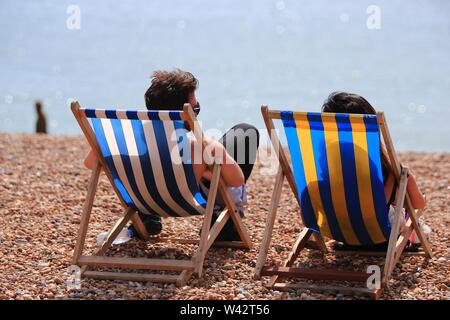 Die Kerben der Leute genießen Sie den Sonnenschein und warme Wetter während der Sommerferien auf Brighton Beach in East Sussex. 14. August 2017 Stockfoto