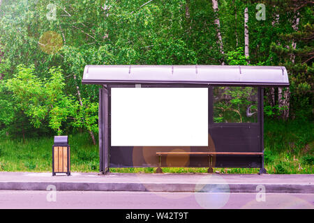 Bushaltestelle in der Nähe der Straße in den Wald. Grüner Hintergrund. Kopieren Sie Platz für Text Stockfoto
