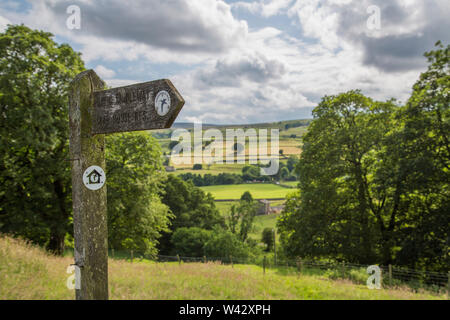 Ein Blick auf eine der vielen Täler in den Yorkshire Dales mit einem öffentlichen Fußweg Zeichen in der foregrund Stockfoto