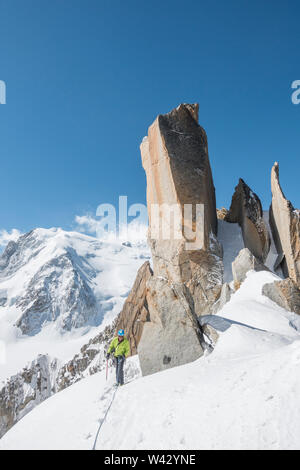Alpinist klettert leichtes Gelände auf der Cosmiques Ridge bei schönem Wetter Stockfoto