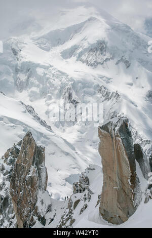 Zwei Alpinisten auf Cosmiques werden von Mt Blanc im Hintergrund in den Schatten gestellt Stockfoto