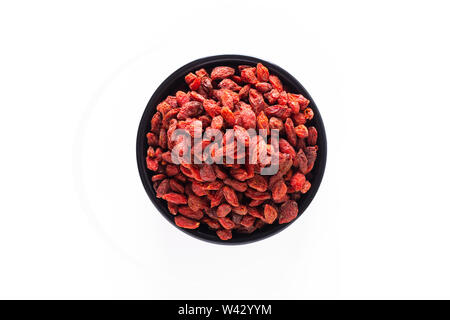 Super Brain Food trocken Goji Beere in Schwarz Keramik Cup auf weißem Hintergrund mit Kopie Raum isoliert Stockfoto