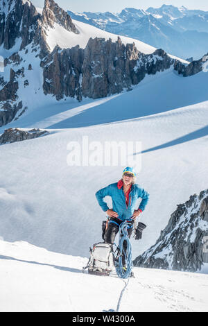 Ein erfahrener Alpinist nimmt einen Bruch hoch oben auf der Aiguille du Chardonnet Stockfoto