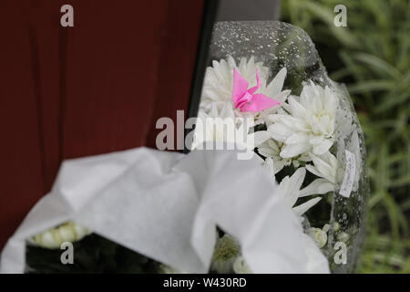 (190719) - Kyoto, Juli 19, 2019 (Xinhua) - Blumen und ein Papier Kran in der Nähe von der Stelle von einem Brandanschlag in Kyoto, Japan, 19. Juli 2019 gesehen. Fachbesucher aus der Japanischen Animation Szene zusammen mit zahllosen Fans zum Ausdruck völliger Schock und Verwirrung Freitag nach der tragischen Ereignisse, die einen Tag früher im Studio von Kyoto Animation Co. in Western Japan durchsickerte. (Xinhua / Du Xiaoyi) Stockfoto