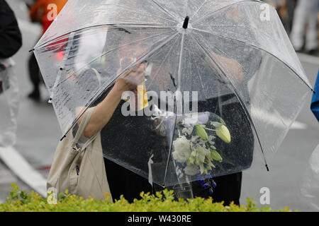 (190719) - Kyoto, Juli 19, 2019 (Xinhua) - eine Frau zahlt floral Tribute in der Nähe von der Stelle von einem Brandanschlag in Kyoto, Japan, 19. Juli 2019. Fachbesucher aus der Japanischen Animation Szene zusammen mit zahllosen Fans zum Ausdruck völliger Schock und Verwirrung Freitag nach der tragischen Ereignisse, die einen Tag früher im Studio von Kyoto Animation Co. in Western Japan durchsickerte. (Xinhua / Du Xiaoyi) Stockfoto