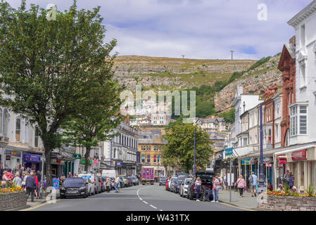 Mostyn Street im Zentrum von Llandudno mit dem Great Orme Kulisse. Stockfoto