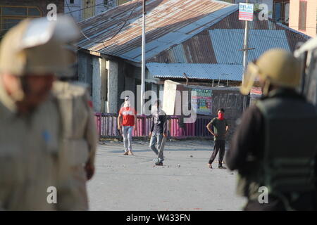 Baramulla, Indien. 17. Juli, 2019. Maskierte Jugend provozieren JK Polizisten mit verschiedenen Gesten. Bald nach den Nachrichten von Militanten Adnan Channa's töten Ausbreitung im Distrikt Baramulla, Menschen der Stadt versammelten sich in Zement Brücke und gegen dieselben protestiert. Adnan wurde in einer Schießerei an Brath Sopore Credit: Raja Faizan Haji/Pacific Press/Alamy Leben Nachrichten getötet Stockfoto