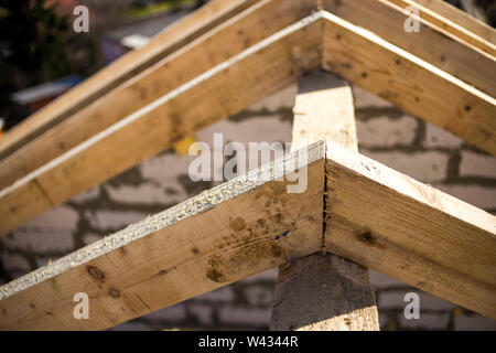 Close-up Detail der Dachrahmen aus grobem Holz Bauholz Balken auf dem Hintergrund von Misty Mountain Landschaft im ökologischen Bereich. Gebäude, Dach, constructi Stockfoto