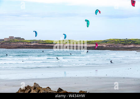 Kitesurfen in Vazon Bay, Guernsey, Kanalinseln UK-Fort Hommet ist im Hintergrund Stockfoto