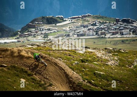 Ein Mountainbiker hinterlässt eine Spur hinter Staub, wie er reitet eine Ecke auf einem Bike Park Trail, hoch über dem Ski Resort Stockfoto