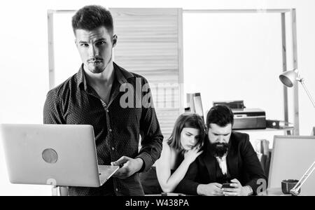 Ein erfolgreiches Unternehmen setzt auf Technologie. Business Technology. Gut aussehender Geschäftsmann mit Laptop, während Kollegen mit Smartphone mobile Technologie. Der Einsatz von Technologie in der Kommunikation mit Kunden. Stockfoto