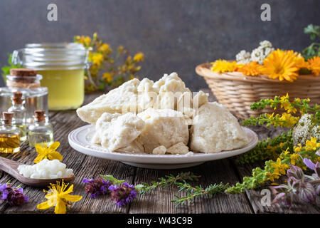 Shea Butter mit Bienenwachs, Heilpflanzen und ätherischen Ölen - Zutaten für die Vorbereitung eine selbstgemachte Creme Stockfoto