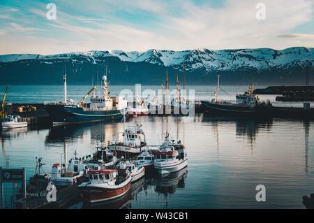 Breite Aufnahme von einem Schiffsanleger mit Booten und schön Felsige schneebedeckte Berge im Hintergrund Stockfoto