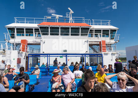 Passagiere auf dem Vorwärts außerhalb Sonnenterrasse sitzen auf der Wightlink Lymington nach Yarmouth Fähre Isle of Wight genießen Sie die Reise an einem sonnigen Sommertag. Stockfoto