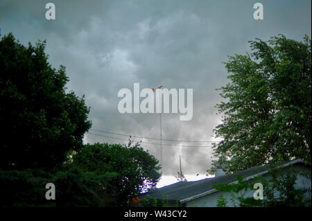 Unwetter und Dunkle, bedrohliche Gewitterwolken Swirl über einen kleinen Hof und Scheune und Nebengebäude und Bäume, Sturm, in Wisconsin, USA. Stockfoto