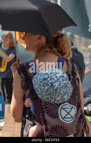 London, Großbritannien. 15. Juli 2019. Mutter Baby an der Climate Action Protest des Aussterbens Rebellion vor dem königlichen Gerichten auf dem Strand, London. Credit: Joe Kuis/Alamy Nachrichten Stockfoto