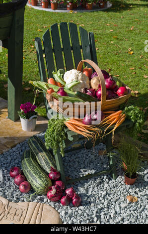 Eine Anzeige der kunstvoll arrangierten frischen Gemüse in einer trug und um einen hölzernen Stuhl, Althorp Essen und Trinken Festival, Northamptonshire, Großbritannien Stockfoto