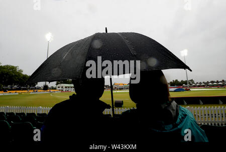 Zuschauer Schutz vor dem Regen unter einem Sonnenschirm während der Vitalität Blast T20 Match bei Fischer Grafschaft Boden, Leicester. Stockfoto