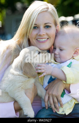 Porträt einer Mutter, Baby und Golden Retriever Welpen Stockfoto