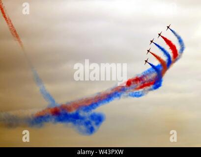 Die RAF Red Arrows Hawk BAE Systems display Team verlassen Spuren der Bunte rote und blaue Kondensstreifen am Himmel über die Bucht von Swansea, Wales, UK. Stockfoto