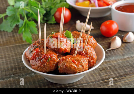 Hausgemachte Frikadellen in Tomatensoße auf weiße Schüssel, Ansicht schließen Stockfoto