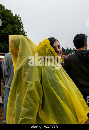 Festivalbesucher Unterschlupf vor dem Regen bei Latitude Festival, henham Park, Suffolk, Großbritannien am 19. Juli 2019 Stockfoto