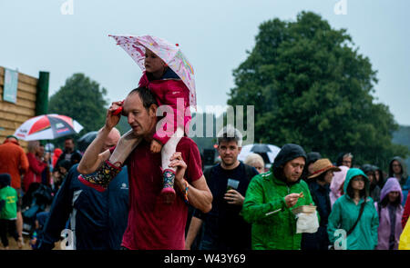 Festivalbesucher Unterschlupf vor dem Regen bei Latitude Festival, henham Park, Suffolk, Großbritannien am 19. Juli 2019 Stockfoto