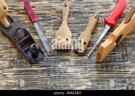 Alte Zimmerhandwerk-werkzeuge, Planer, handsägen und Zyklen liegen auf einem Holztisch. Stockfoto