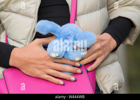 Hände Mädchen auf dem stilvollen rosa Beutel, Fell Spielzeug Kaninchen Stockfoto