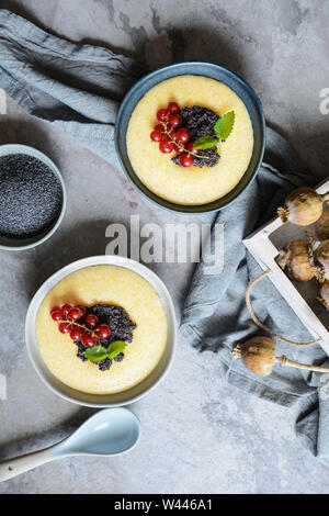 Leckeres Frühstück, süßen Brei aus Maismehl aufgefüllt mit Mohn und Johannisbeeren Stockfoto
