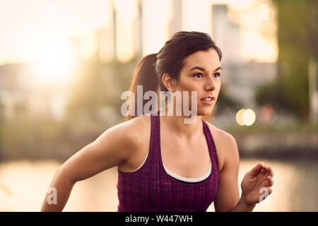 Portrait einer weiblichen Athleten bei Dämmerung mit Sonnenuntergang auf die Stadt Montreal im Hintergrund Stockfoto