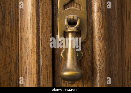 Messing griff closeup in Holzrahmen auf Schranktür Stockfoto