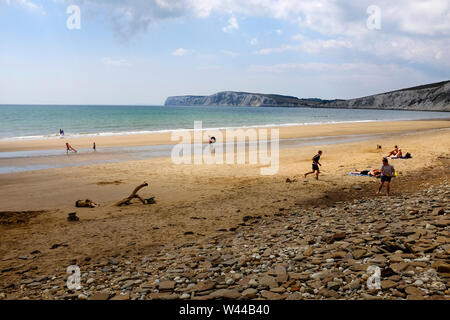 Blick auf den Strand mit mehreren Aktivitäten am Strand bei Ebbe auf einer sandigen Küste in Compton Chine Beach, Compton Bay, Isle of Wight, Großbritannien. Stockfoto