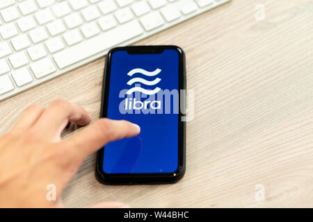 12 Juli 2019, Ljubljana Slowenien - Hand berühren Smartphone mit Waage Logo auf. Facebook Neue globale cryptocurrency für Transaktionen Stockfoto