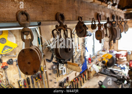 Eine Detailansicht auf altmodische anheben Rädern über eine Metallwerkstatt. Teil einer Flaschenzug System mit Seilen verwendet, um schwere Gegenstände anzuheben. Stockfoto