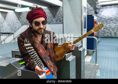 Ein heiliger Mann schaut aus, als er in einer U-Bahn Station steht, holding Eagle Feather Weisheit und den Mut, zu symbolisieren, schaut in Richtung Kamera tragen Stockfoto