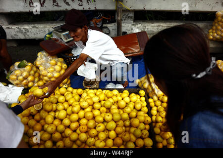 ANTIPOLO CITY, Philippinen - 17. Juli 2019: einem Straßenhändler verkauft frisches und reife Zitrone auf einem Bürgersteig entlang einer Autobahn. Stockfoto