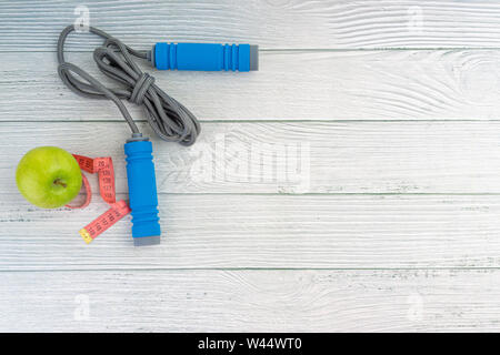 Top oder flach auf Apple Obst und Springseil mit Kopie Raum auf Holz- Hintergrund. Gesundes Konzept. Selektive konzentrieren. Stockfoto
