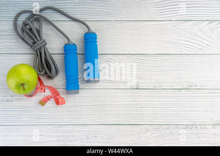 Top oder flach auf Apple Obst und Springseil mit Kopie Raum auf Holz- Hintergrund. Gesundes Konzept. Selektive konzentrieren. Stockfoto